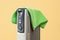 Green towel dries on the hot oil filled heater against yellow background. Portable space heater covered with a towel. Dangerous