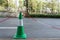 Green traffic cone with red and white chains for parking