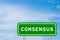 Green transportation sign with word consensus on blue sky with white cloud background