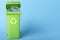 Green trash can with plastic waste and recycling icon on a blue background with place for text