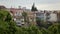 Green trees in Tbilisi park, buildings on hill, architecture of Georgian capital