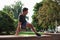 Green trees. Young sports man doing parkour in the city at sunny daytime