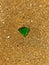 Green triangle glass on the yellow sand