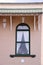 Green-trimmed arched window in peach brick Victorian building