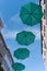 Green umbrellas hanging along the street