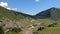 Green valley with mountains, road and blue sky, lockdown view