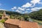 Green valley and river Tarn, Church of St. Christopher and entrance of Peyre village and Millau Viaduct. Aveyron, Occitania,