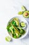 Green vegan tacos with broccoli, avocado and green flat bread in white bowl, white marble background. Vegetarian fast food
