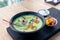 Green vegetable soup with mangold, crab meat and mango on black board