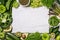 Green vegetables and fruits, greens and legumes and a white marble board on a white background. Healthy food and clean eating