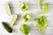 Green vegetables and herbs  , whole and halves of  sweet pepper, cucumber, green lettuce leaves on a white wooden background, top