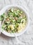 Green vegetables quinoa salad for a spring detox. Salad with quinoa, avocado, cucumbers, arugula, walnuts, ginger and seeds. On a