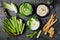 Green vegetables raw snack board with various dips. Yogurt sauce or labneh, hummus, herb hummus or pesto with crackers, grissini