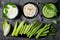 Green vegetables raw snack board with various dips. Yogurt sauce or labneh, hummus, herb hummus or pesto with fresh vegetables.