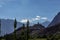 Green vegetation with mountain top and distant impression of an idol over a hill temple with deep blue sky at ladakh, Kashmir,