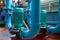 Green vertical motors with pumps on a blue colored water pipeline