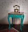 Green vintage wooden table and old golden telephone set