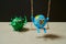 Green virus catching a toy earth on a swing