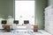 Green wall office with wooden tables and window, white chairs and bookshelf