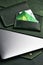 green wallet and genuine leather laptop case and cardholder lie on table