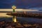 Green WarnemÃ¼nde Lighthouse with ship in the dark