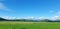 Green Welsh landscape and mountains with blue sky and white fluffy clouds background