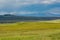 Green wetland field with mountain on the background