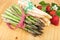 Green white asparagus with fresh strawberries on bright wood. Vegan food, vegetarian and healthy cooking concept.