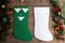 Green and white Christmas stockings hanging on wooden background with Christmas decoration with fir tree and cones