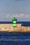 Green and White LIghthouse on Seawall