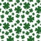 Green and white shamrock on seamless background