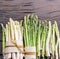 Green and white types of asparagus sprouts on wooden table. Top