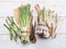 Green and white types of asparagus sprouts on wooden table.  Top view