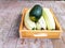 Green and white zucchini in the wooden box