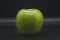 green whole apple granny on a black background