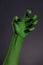 Green witch hand with sharp black nails, real body-art