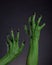 Green witch hands with black nails stretching up, real body-art