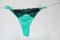 Green women`s thong panties on a clothesline fastened with white pegs