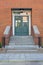 Green wooden door on the red brick wall