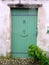 Green wooden door in a seaside village.