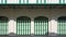 Green wooden folding arches doors with awning on vintage white building wall