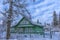 Green wooden house in winter in russian village