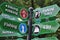 Green wooden sign with directions in the park guiding to Fishing, City, Biking Hiking and Parking