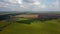 Green yellow agricultural farm fields, fast moving shadows on earth, clouds sky