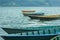 A green yellow and blue old wooden boat on the water against the backdrop of green mountains. empty boats