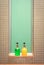 Green and yellow bottles of soap and shampoo against green glass and tiled wall