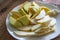 Green yellow crispy mango sliced in a white plate