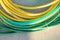 Green and yellow hoses in the backyard. Gardening concept, horizontal photo