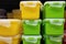 Green and yellow plastic containers with a lid, close up.