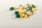 Green, yellow tramadol capsule pills on white background.Pain killer capsules called